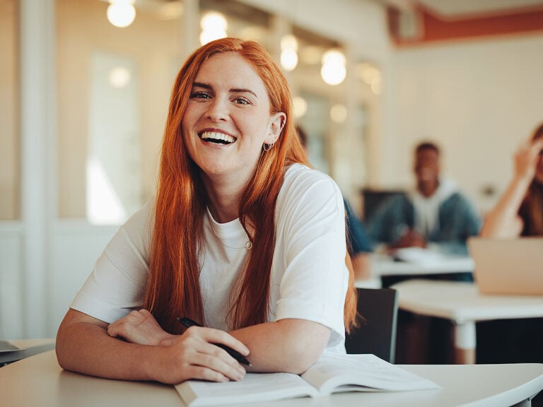 High school girl in school at desk with book